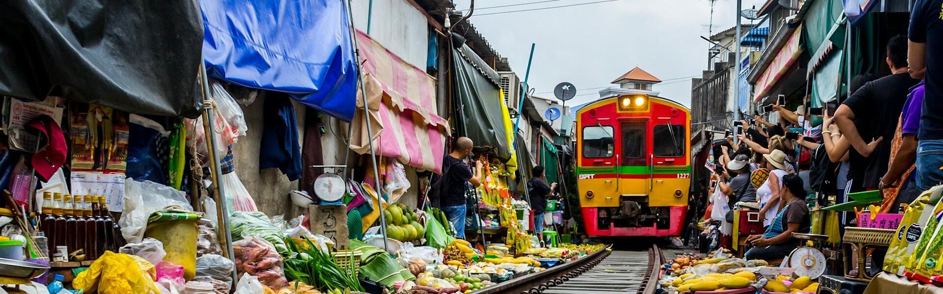 Iconic train tracks through Mae Klong Market for a Mae Klong Tours banner with Legend Travel Group.